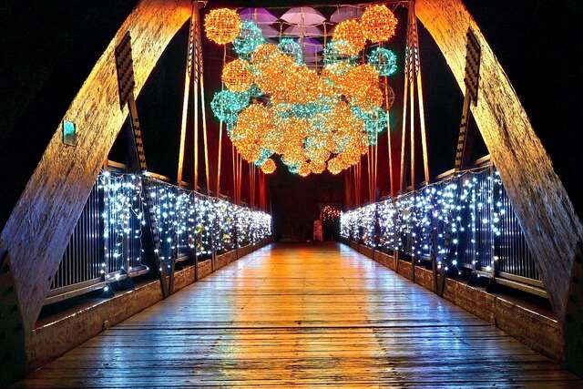 情人木桥园区的-光乍爱情桥-以紫色伞海搭配暖白蓝色系的铁骨球水滴