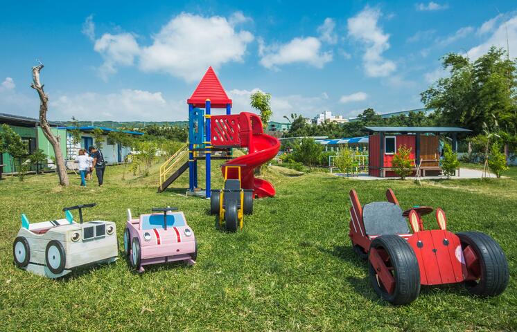 草地上設置溜滑梯與小型遊樂設施 提供親子遊樂