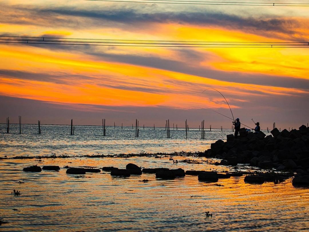 夕陽與大海渲染，倒映著漁港上每位釣客的身影。

The sunset and the ocean render to reflec...